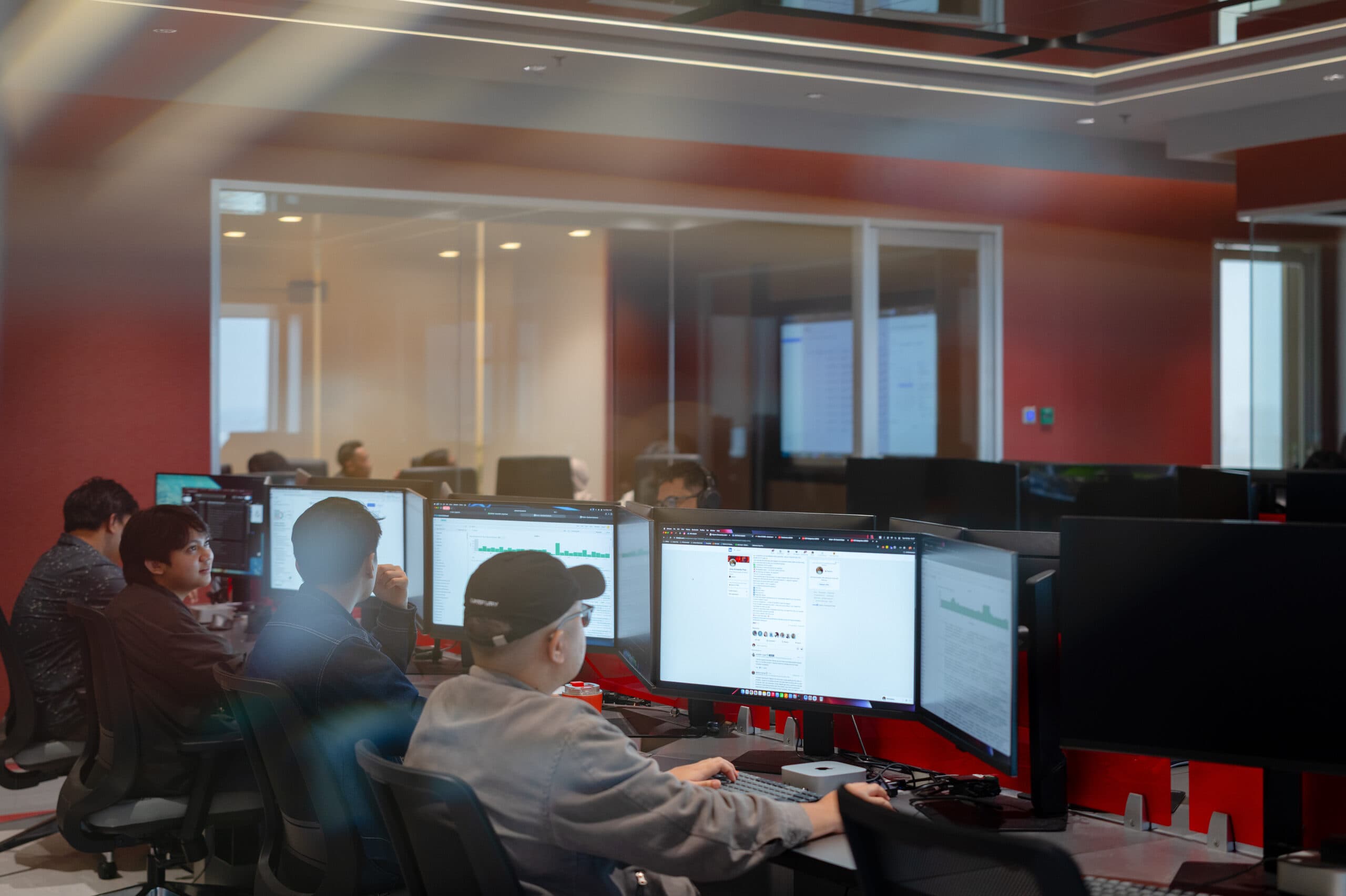 Analysts at multi-monitor stations on the operations floor