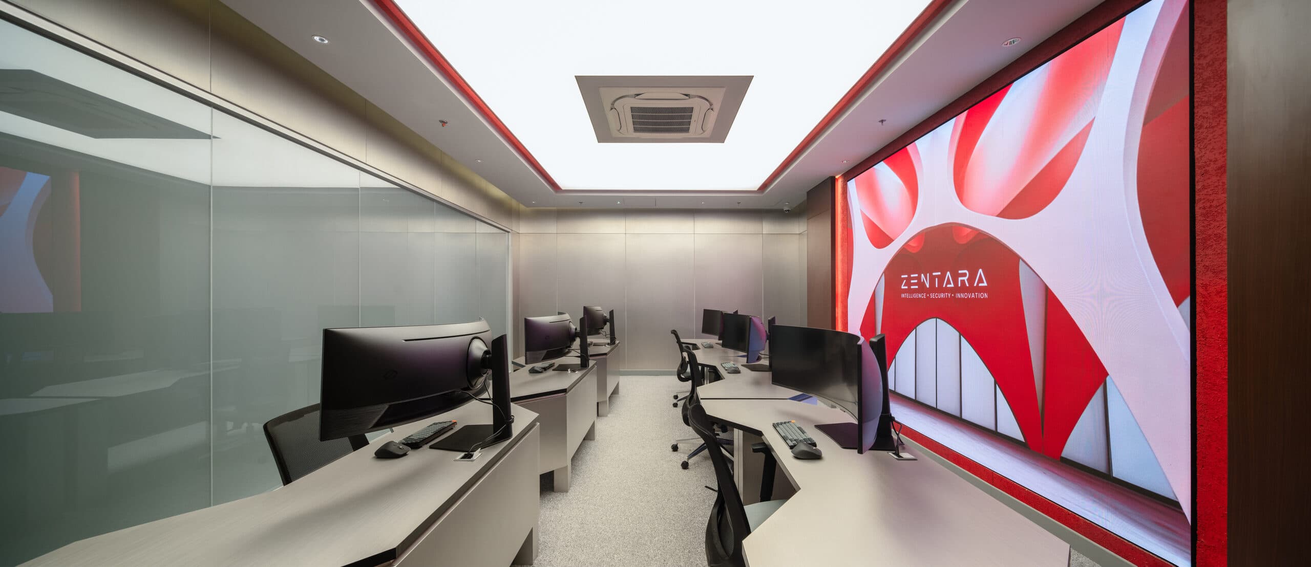The Zentara SOC — the 24/7 watch room in Jakarta, red ZENTARA display wall over the analyst stations